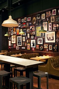 a restaurant with many pictures on the wall and leather chairs in front of it,