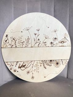 a wooden plaque with flowers and butterflies painted on it