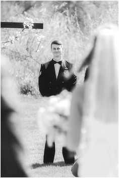 a black and white photo of a man in a tuxedo at a wedding