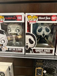 three pop vinyl figures are on display in a toy store, one is white and the other is black