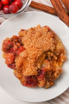 a close up of a plate of food with cranberries and cinnamon sticks in the background