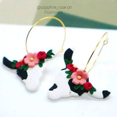 the cow has flowers on it's earwires and is decorated with gold hoop earrings