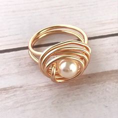 Beautiful and Unique Gold Wire Wrapped Ring, ideal for an special gift for her, perfect to give any outfit a classic, feminine look. This modern pearl ring makes a great gift for bridesmaids and women of any age. This ring is made with a 3mm round pearl and wrapped in non tarnish gold wire, it is Ring Pearl Modern, Gold Wire Ring, Gold Wrap Ring, Braided Bracelet Diy, Wire Jewelry Rings, June Birthstone Ring, Copper Wire Jewelry, Ring Pearl, Ring Wire