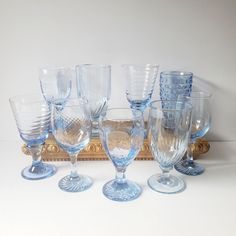 a group of glasses sitting next to each other on top of a table in front of a mirror