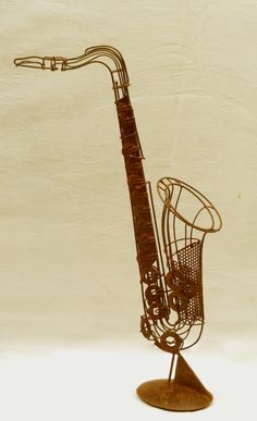 a metal sculpture of a saxophone on a stand