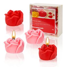 three red candles are sitting next to each other in front of a card board box