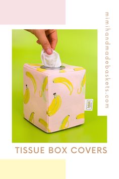 the tissue box covers are yellow and green with bananas on it, as well as a hand holding a napkin