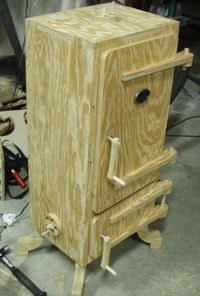 a wooden stove sitting on top of a floor next to a tool box and other tools