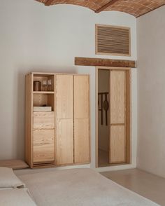 a bedroom with a bed, dresser and air conditioner on top of the wall