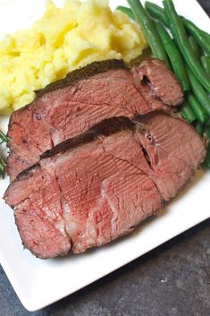 a white plate topped with meat and green beans