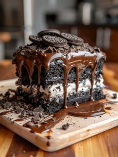 a chocolate cake with oreo cookies and cream frosting on a cutting board, ready to be eaten