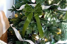 a christmas tree decorated with white and green ribbon