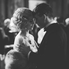 black and white photograph of a man and woman in formal wear embracing each other at an event