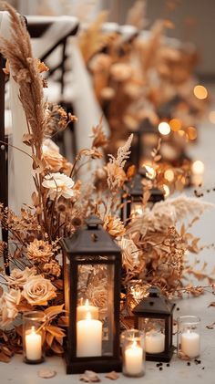 candles and flowers are sitting on the floor next to some lanterns with lights in them