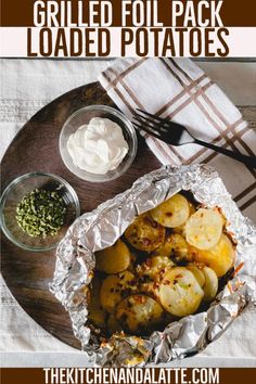 grilled foil - pack loaded potatoes on a plate with sour cream and seasoning