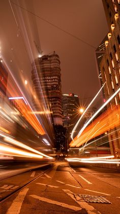 the city is lit up at night with long exposures and blurry light streaks