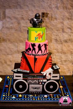 a multi - tiered cake is decorated with music equipment