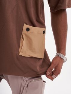 This coffee colored baggy T-shirt is the perfect addition to any beatnik's wardrobe! The button design and the asymmetrical hem gives it a stylish edge. The pocket is both functional and stylish, making this T-shirt a must-have for any fashion-savvy individual. FEATURES- Regular Cut- Smooth Feel- Comfort Fit- 95% cotton, 5% lycra SIZE RECOMMENDATIONModel is a regular size Large and he is wearing size Large Brown Cotton T-shirt With Pockets, Relaxed Fit Brown T-shirt With Pockets, Brown Tops With Pockets For Streetwear, Oversized Brown Tops With Pockets, Brown Tops With Pockets For Everyday, Brown Everyday Tops With Pockets, Brown Crew Neck Top With Pockets, Casual Brown Tops With Side Pockets, Khaki Crew Neck T-shirt With Pockets