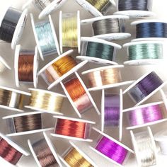 many spools of thread are arranged on a white surface