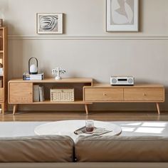 a living room filled with furniture and a book shelf next to a tv on top of a wooden stand