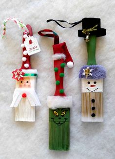 three christmas decorations made out of toothpicks on a white surface, one with santa's hat and the other decorated