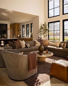 a living room filled with furniture and large windows