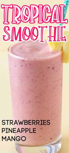 a pink smoothie in a glass with a lemon wedge on the rim and text tropical smoothie strawberry pineapple mango