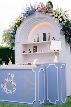 an outdoor bar is decorated with flowers and gold trimmings, along with other decorations