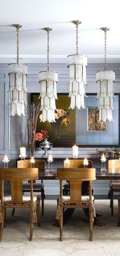 an elegant dining room with chandeliers hanging from the ceiling and candles on the table