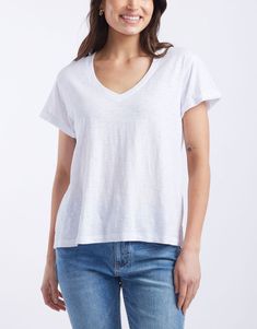 DESCRIPTION Elevate your everyday wardrobe with the Turn Back V Neck T-Shirt in White by White & Co. The Label. This classic white tee features a flattering V-neckline and a relaxed fit, making it an essential staple for any outfit. The turn back cuffs add a subtle yet stylish detail, enhancing the overall look. Perfect for layering or wearing on its own, this versatile T-shirt combines comfort and elegance effortlessly. Pair this T-shirt with wide leg jeans and sneakers for a laid-back, casual Wide Leg Jeans And Sneakers, Colorful Skirts, White Tee, Everyday Wardrobe, Classic White, Statement Jewelry, Wide Leg Jeans, The Label, Fabric Care