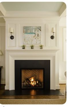 a fire place in the middle of a living room with two lamps on either side