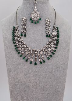 This necklace would make a wonderful accessory choice for the festive season. Its circular floral pattern and beautiful ethnic maang tikka are a great reflection of the rich traditions and aura of our festivals. Neckline Length: 7.5" and The length of the necklace is adjustable by a chain. Earrings Length: Approx. 2" Weight of each earring: 6 gms Push-Back Closure. Tikka length: 1.5" Weight: 10 gms Victorian Finish on high-quality brass as the base metal Availability: In-Stock *Color may vary sl Bollywood Style Round Necklace For Celebrations, Bollywood Style Round Necklaces For Celebrations, Kundan Round Necklace For Parties, Silver Hand Set Jewelry For Eid, Silver Jewelry Sets For Eid, Round Necklaces For Diwali Celebration, Festive Round Necklace With Stone Work, Diwali Celebration Necklaces, Silver Tilla Jewelry Sets For Eid