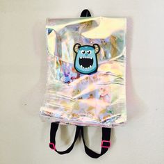 a bag with a monster face on it hanging from the side of a white wall