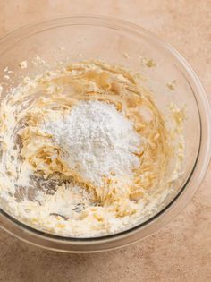 a glass bowl filled with batter on top of a table