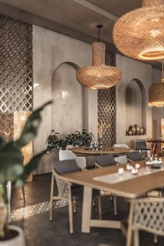 a restaurant with tables, chairs and lights hanging from the ceiling above them is decorated in wicker