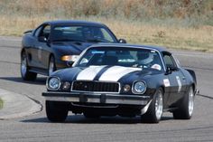 two cars driving on a race track next to each other