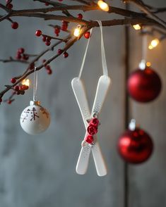 christmas ornaments hanging from a tree with red and white baubles on it's branches