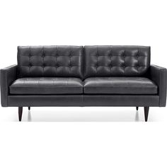 a black leather couch sitting on top of a white floor