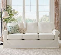 a living room with a white couch and large window in it's center area