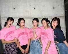 four young women in pink shirts posing for a photo with their arms around each other