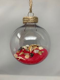 a glass ornament filled with shells and sand