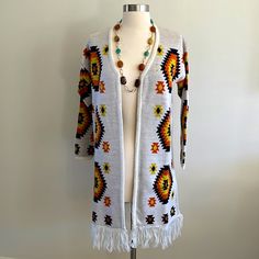 a woman's white cardigan sweater with multicolored beads and tassels