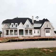 a large white house sitting on top of a lush green field