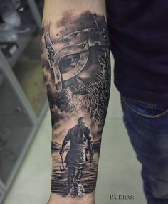 a man's arm with a black and white tattoo on it, depicting a viking warrior