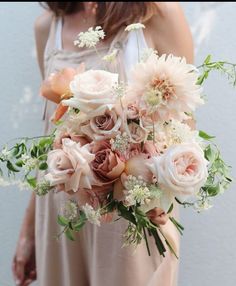 a woman holding a bouquet of flowers in her hands