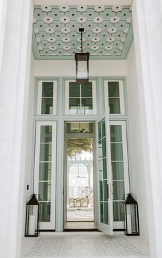 an open door with two lanterns hanging from the ceiling