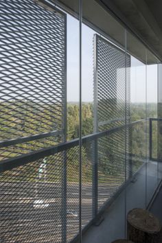 a balcony with glass railings and trees in the background