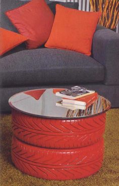 a living room with a gray couch and orange pillows on the side table in front of it