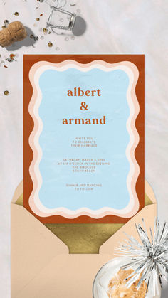 an open envelope with the words albert and armand on it, surrounded by confetti