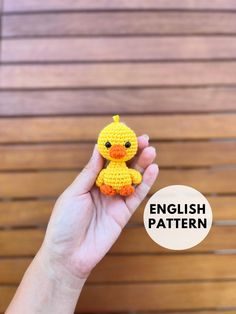 a hand holding a small yellow crocheted duck